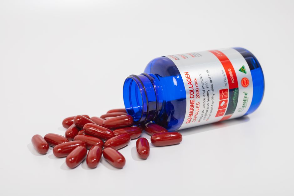 Een gezonde vrouw die een collageensupplement in haar hand houdt, met een stralende huid en blije uitstraling.